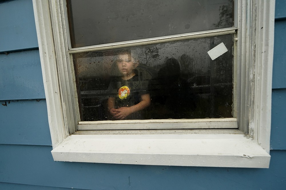Hunter Daniel, 3, looks out the window of his uncle's house, to which his family temporarily relocated to ride out Hurricane Delta which is expected to make landfall later in the day, in Lake Charles, La., Friday, Oct. 9, 2020. (AP Photo/Gerald Herbert)