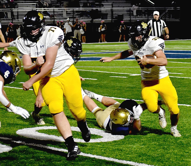 MARK HUMPHREY  ENTERPRISE-LEADER/Prairie Grove senior fullback Foster Layman, shown following the block of sophomore Reed Orr, proved tough to tackle all night. Layman scored  a pair of rushing touchdowns in the Tigers' 42-28 loss to the Saints Friday as Prairie Grove suffered its first setback of the season.