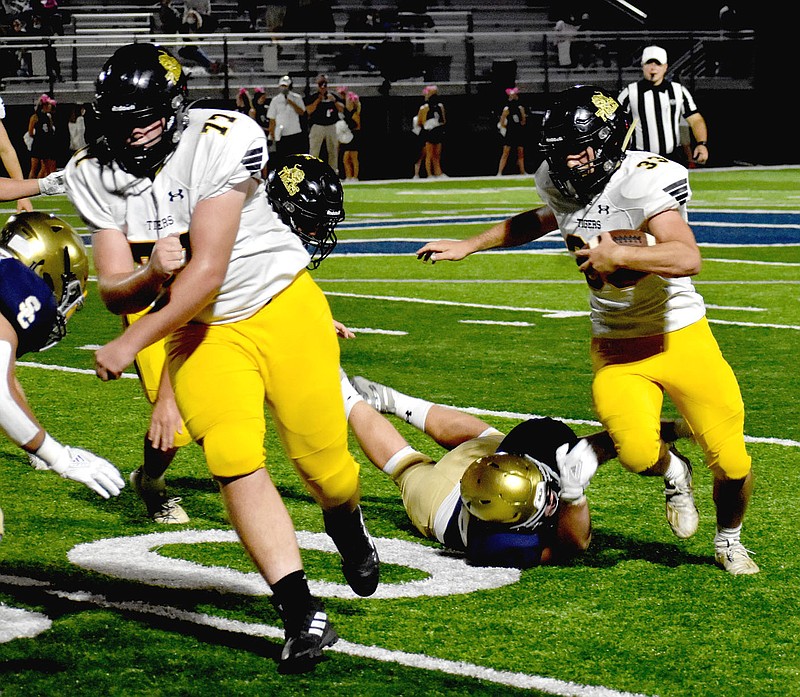 MARK HUMPHREY ENTERPRISE-LEADER/Prairie Grove senior fullback Foster Layman, shown following the block of sophomore Reed Orr, proved tough to tackle all night. Layman scored a pair of rushing touchdowns in the Tigers' 42-28 loss to the Saints Friday as Prairie Grove suffered its first setback of the season. story.lead_photo.caption