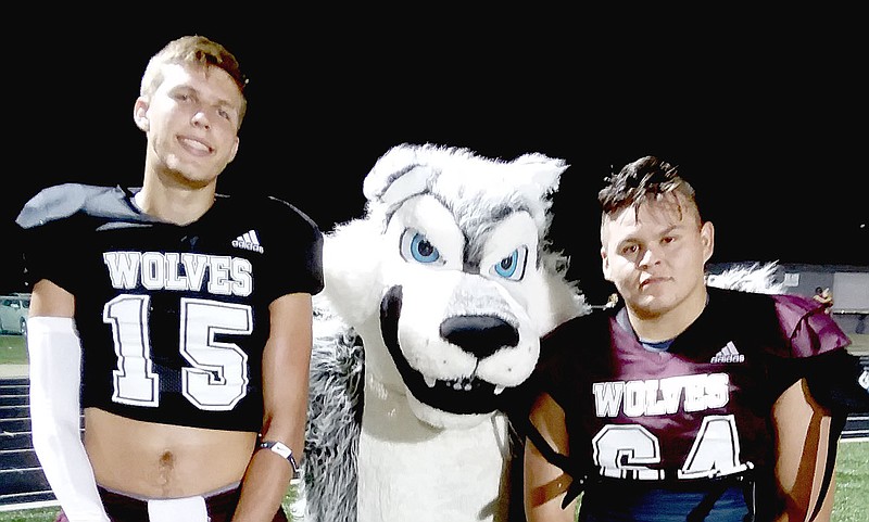 MARK HUMPHREY  ENTERPRISE-LEADER/Lincoln seniors Tyler Brewer (left) and Kris Martinez pose with the Wolf mascot. The Wolves lost a thriller, 36-35, at Greenland during the final minute Friday.