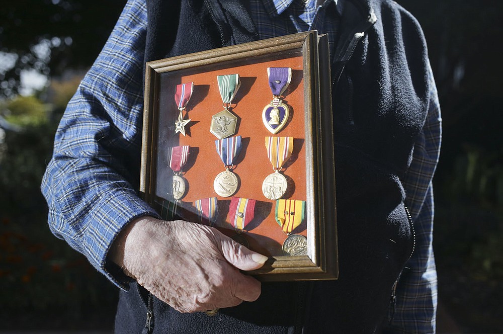 Albert King holds his medals, Friday, October 2, 2020 at the Fayetteville Square in Fayetteville. Check out nwaonline.com/2010010Daily/ for today's photo gallery.
(NWA Democrat-Gazette/Charlie Kaijo)