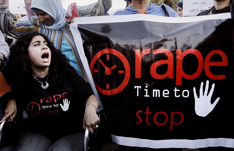 In this June 14, 2014 file photo, Egyptian women shout slogans and hold banners during a protest against sexual harassment in Cairo, Egypt. An announcement last month that Egyptian authorities would investigate an alleged 2014 gan rape of a 17-year old girl at a Cairo hotel was welcomed as a rare moment of triumph by rights activists who now fear the government is trying to discourage victims and witnesses from speaking out.   (AP Photo/Amr Nabil, File)
