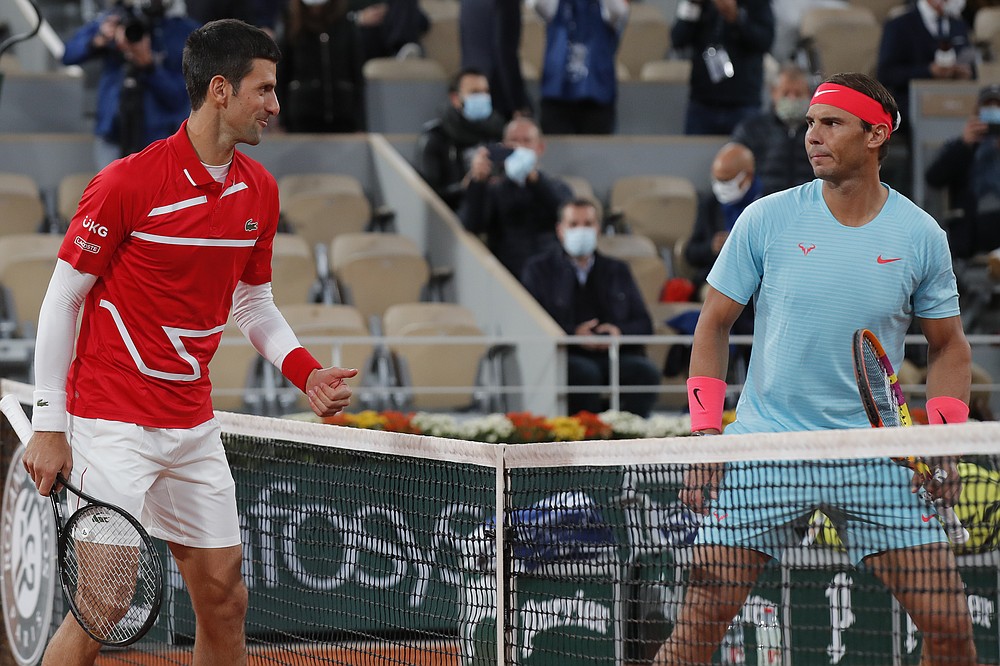Serbia's Novak Djokovic, left, and Spain's Rafael Nadal look at each other as they pose for images prior to the final match of the French Open tennis tournament at the Roland Garros stadium in Paris, France, Sunday, Oct. 11, 2020. (AP Photo/Michel Euler)
