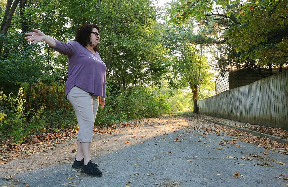Karen Hill next to her property on Angela Street and W. Emma Avenue as she describes Wednesday, October 7, 2020, the impact on her property of the presented plans to extend Har-Ber Avenue east over I-49 to match up with Emma Avenue at Gutensohn Road in Springdale. Check out nwadg.com/photos for a photo gallery.(NWA Democrat-Gazette/David Gottschalk)