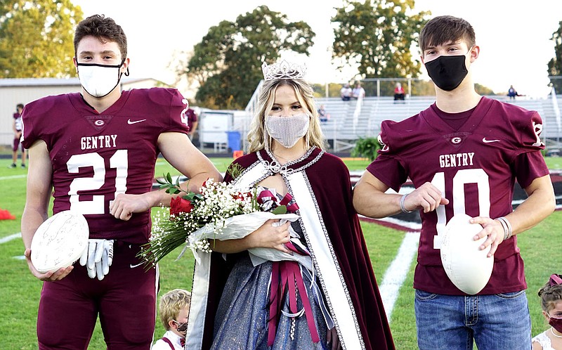 Westside Eagle Observer/RANDY MOLL
With the ceremonial kiss out this year due to covid-19 restrictions, Gentry football captains Seiren Reding and Zach Jarnagan give Emma Anderson an elbow bump after she was crowned 2020 homecoming queen during ceremonies in Pioneer Stadium on Friday night.