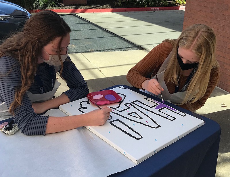 Chloe Thomson (left) and Abigail Alexander, students in the Bentonville School District's Ignite Professional Studies Program, help paint one of the pieces of the Peanuts mural that will be installed at Northwest Medical Center in Bentonville.
(Courtesy Photo/Northwest Medical Center)