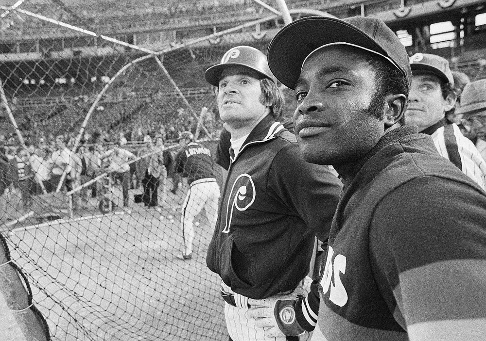FILE - In this Tuesday, Oct. 7, 1980, file photo, former Cincinnati Reds teammates,  Phillies' Pete Rose, left, and Astros' Joe Morgan stand together watching the Phillies finish batting practice before a National League playoff baseball game in Philadelphia. Hall of Famer Joe Morgan has died. A family spokesman says he died at his home Sunday, Oct. 11, 2020, in Danville, Calif. (AP Photo/File)