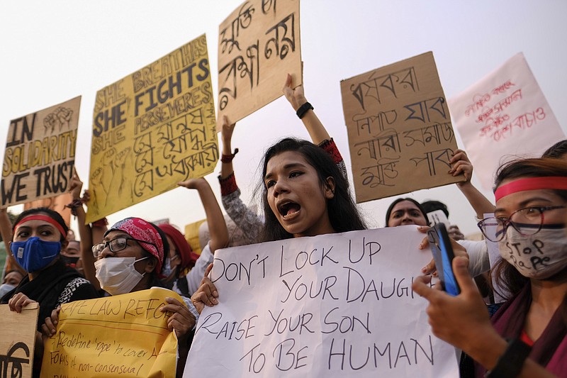 Women’s rights activists and others protesting against gender based violence hold placards outside the Parliament in Dhaka, Bangladesh, Friday, Oct.9, 2020. Bangladesh's Cabinet has approved an increase in the maximum punishment in rape cases to death from life imprisonment after a series of recent sexual assaults triggered protests.  (AP Photo/ Mahmud Hossain Opu)