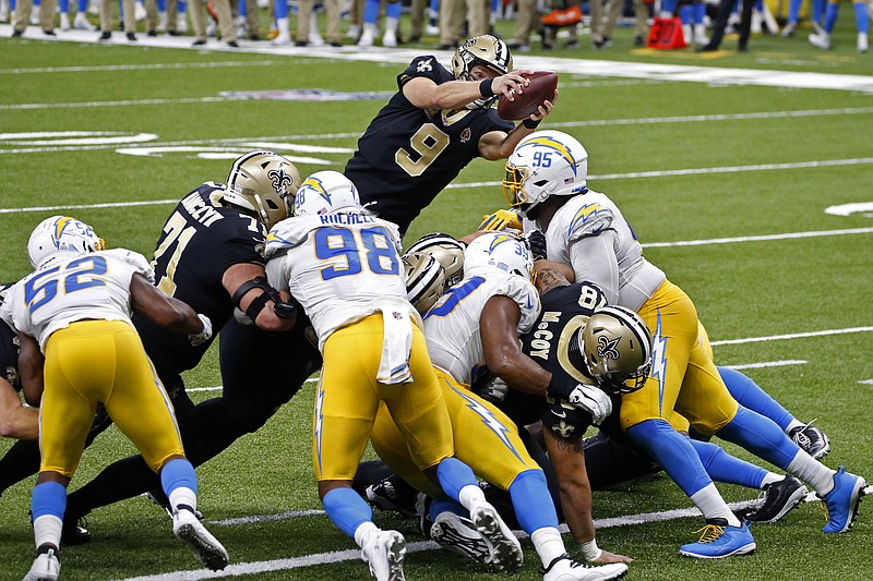 New Orleans Saints quarterback Drew Brees (9) dives over the goal line for a touchdown in the first half of an NFL football game against the Los Angeles Chargers in New Orleans, Monday, Oct. 12, 2020. (AP Photo/Butch Dill)
