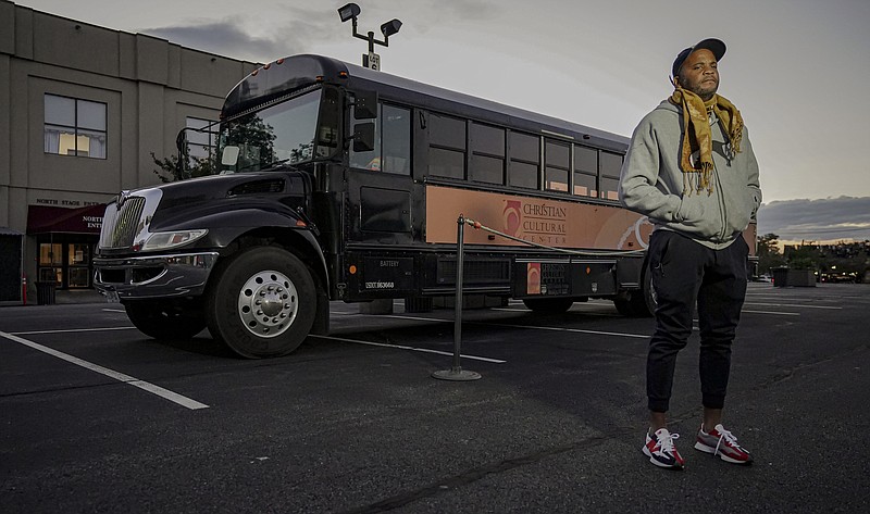 Attorney Keith White, a director of social justice initiatives at Christian Cultural Center, stands next to a bus the church plans to update with covid-19 protocols to transport people to and from the polls on Election Day.
(AP/Bebeto Matthews)