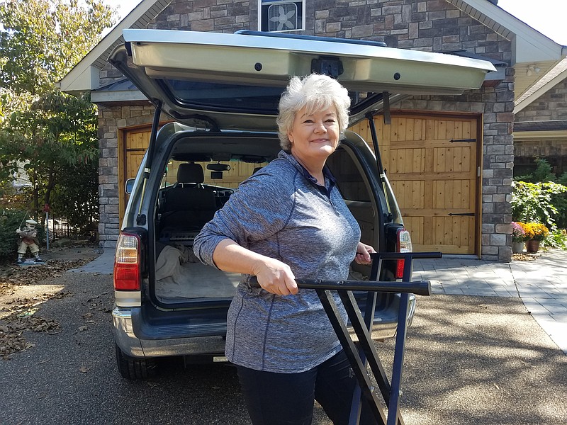 U.S.D. 1812 member Kim Bailey loads the music stand for delivery to CAVHS VAVS. (Special to The Commercial)