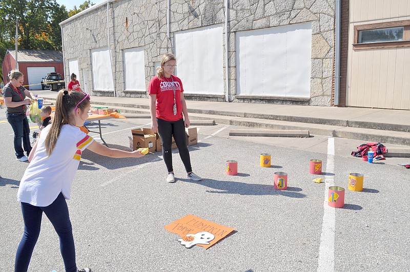 RACHEL DICKERSON/MCDONALD COUNTY PRESS Ruby Frazier, 7, of Pineville, plays Pumpkin Pong at the Pineville Fall Festival.