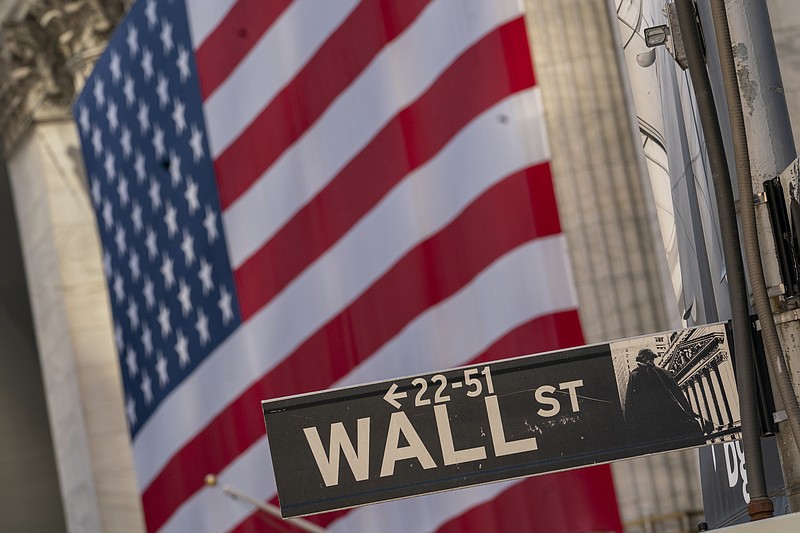 FILE - In this Monday, Sept. 21, 2020, file photo, the Wall Street sign is framed by a giant American flag hanging on the New York Stock Exchange. Stocks are edging lower on Wall Street in early trading, Tuesday, Oct. 13, 2020, as the market cools off following a four-day rally. (AP Photo/Mary Altaffer, File)
