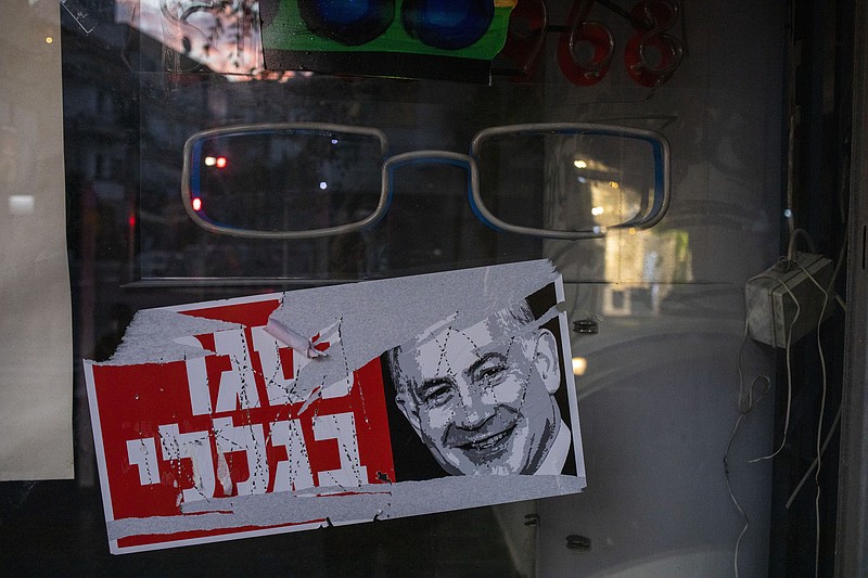 A poster reads "closed because of me " with an image of Israel's Prime Minister Benjamin Netanyahu on a closed shop in Tel Aviv, Israel, Tuesday, Oct. 13, 2020. Israel has had one of the largest income gaps and poverty rates among developed economies, even before the coronavirus pandemic. The country has a few high earners concentrated in the lucrative high-tech sector, while many Israelis barely get by as civil servants, in service industries or as small business owners. (AP Photo/Ariel Schalit)