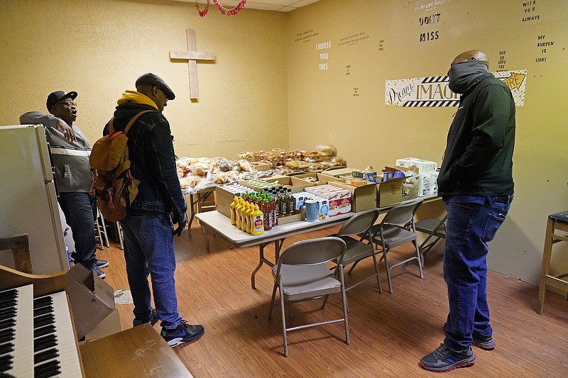 New Mount Calvary Baptist Church members Marles Cooper, right, and Deacon Will, left, visit with DuWayne Evans who rode up on his bicycle and picked up a piece of pie from the church food shelf Thursday, Oct. 1, 2020, in North Minneapolis. In addition to food assistance, Bishop Divar L. Bryant Kemp makes a plea year-round to both his congregants and others outside of his church to get out and vote, emphasizing the efforts of past civil rights leaders that fought for Black citizens to receive that right. (AP Photo/Jim Mone)