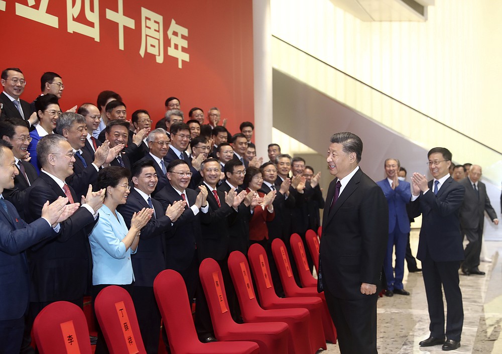 In this photo released by China's Xinhua News Agency, Chinese President Xi Jinping reacts as attendees applaud during an event to commemorate the 40th anniversary of the establishment of the Shenzhen Special Economic Zone in Shenzhen in southern China's Guangdong Province, Wednesday, Oct. 14, 2020. President Xi Jinping promised Wednesday new steps to back development of China's biggest tech center, Shenzhen, amid a feud with Washington that has disrupted access to U.S. technology and is fueling ambitions to create Chinese providers. (Ju Peng/Xinhua via AP)