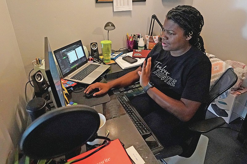 A Chicago charter school teacher Angela McByrd works on her laptop to teach remotely from her home in Chicago, Thursday, Sept. 24, 2020. Most students in Illinois have been starting remote learning this fall, according to results from an Illinois State Board of Education survey. (AP Photo/Nam Y. Huh)