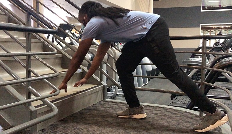 Emmanuel Eyiuche gets into position for the Staircase Pushup Progression. (Arkansas Democrat-Gazette/Celia Storey)