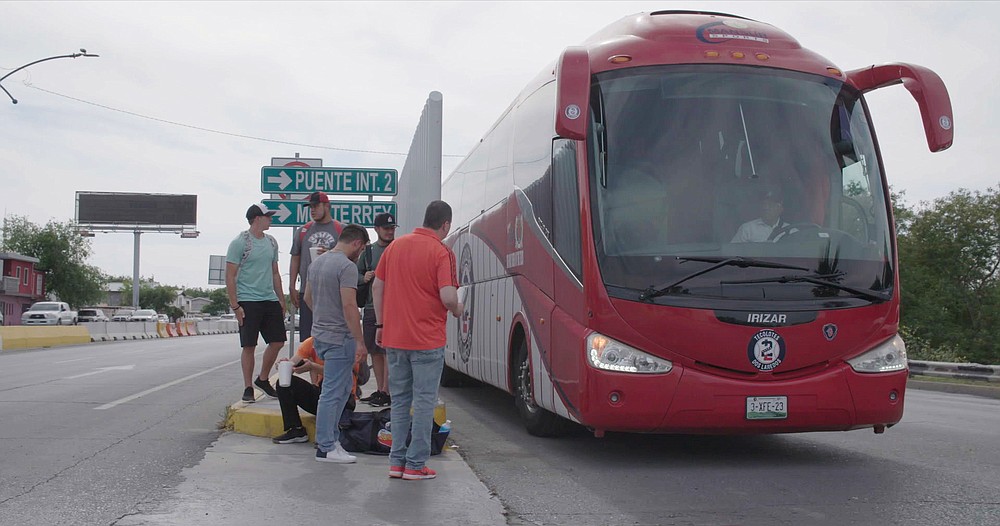 Members of the Tecolotes de los Dos Laredo, a binational professional baseball team with home stadiums in Nuevo Laredo, Mexico, and Laredo, Texas, board a bus in Nuevo Laredo to travel to an away game during the 2019 season in a scene from "Bad Hombres." The new Showtime sports documentary follows this AAA Mexican League baseball team that plays on both sides of the U.S.-Mexico border amid the tension around migration, divisive politics, and environmental concerns. (Showtime via AP)