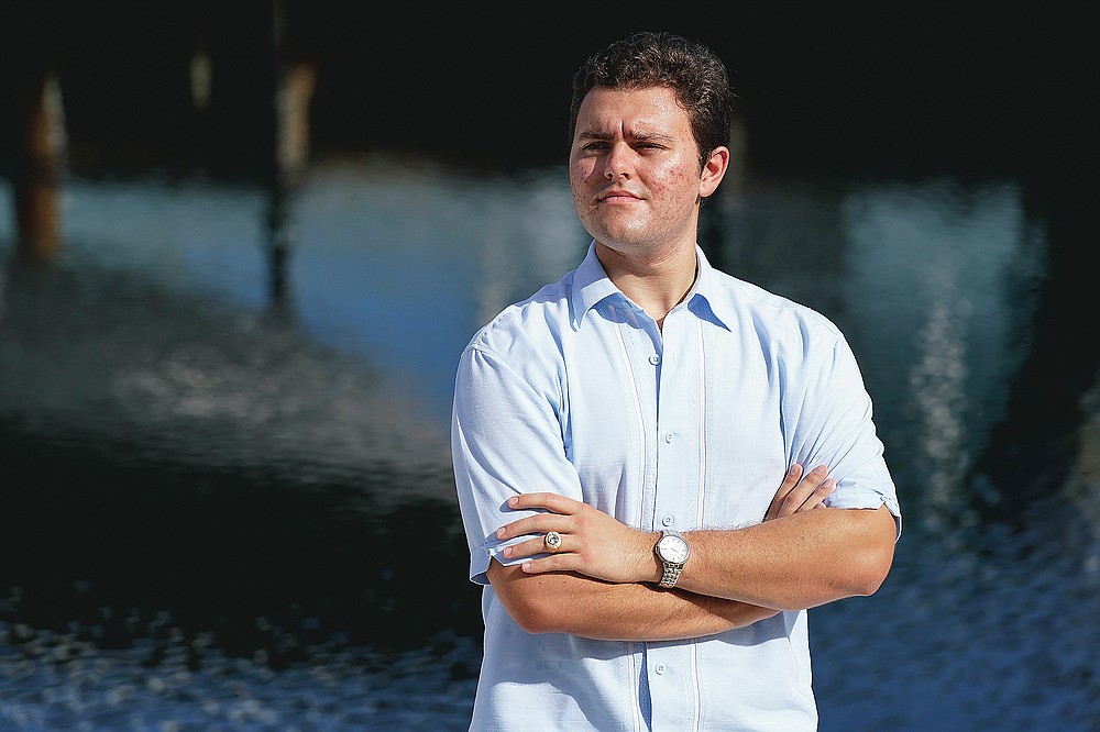 Freddy Vallejo Jr. poses for a photograph, Saturday, Sept. 26, 2020, at the family vacation home in Key Largo, in the Florida Keys. His grandfather Jorge Vallejo, a retired OB-GYN, and uncle Carlos Vallejo, who practiced internal medicine, died of the coronavirus within weeks of one another in South Florida. (AP Photo/Lynne Sladky)