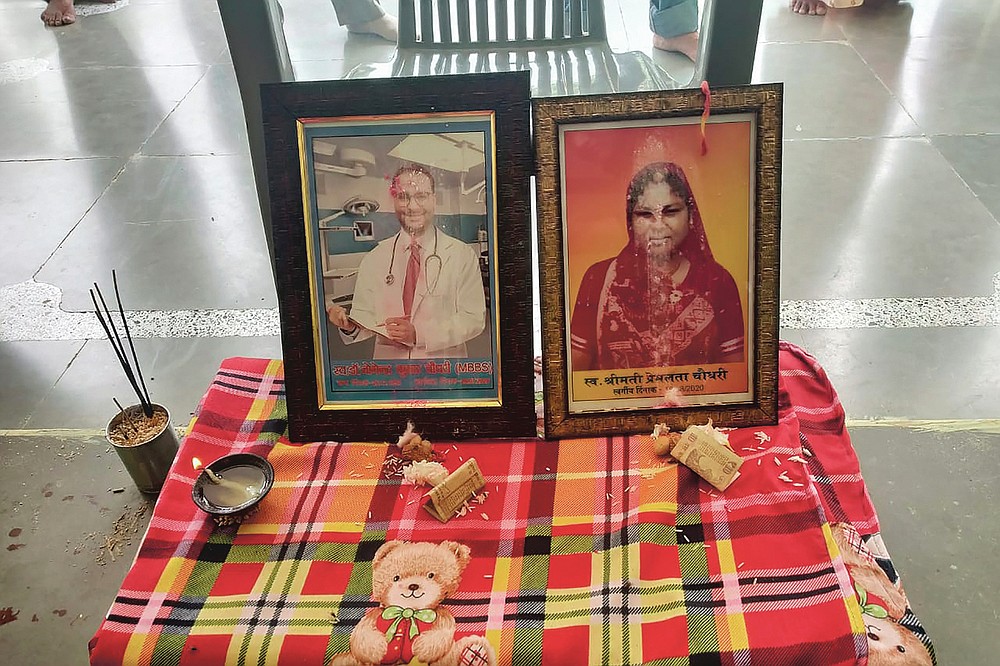 In this Sept. 17, 2020 photo provided by Kapil Chaudhary shows pictures of Joginder Chaudhary and his mother Premlata Chaudhary sitting on a table during a Hindu mourning ceremony held at the family home in Jhantala, Madhya Pradesh, India. fter the virus killed the 27-year-old Chaudhary in late July 2020, his mother wept inconsolably. With her son gone, Premlata Chaudhary said, how could she go on living? Three weeks later, on Aug. 18, the virus took her life, too — yet another number in an unrelenting march toward a woeful milestone. (Courtesy of Kapil Chaudhary via AP)