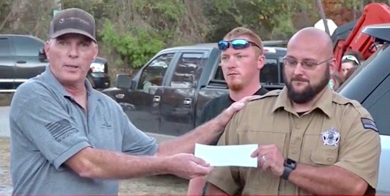 Submitted Photo
Richard "Bigo" Barnett (left), of Gravette, cofounder of 2nd Amendment rights group 2A NWA STAND!, presents a check to Sulphur Springs police chief Jarod Morgan, for purchase of body cams for Sulphur Springs officers. Also pictured at the Oct. 13 check presentation is Lindsey Ryan, group member. Funds were raised at the group's Back the Blue rally and auction Oct. 10 at Rogers.