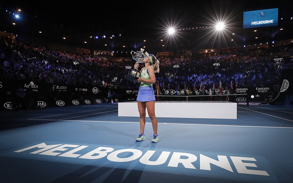 FILE - In this Feb. 1, 2020, file photo, Sofia Kenin, of the United States, kisses her trophy after defeating Spain's Garbine Muguruza in the women's singles final at the Australian Open tennis championship in Melbourne, Australia. Australian Open chief executive Craig Tiley says he wants international tennis players arriving for January's first Grand Slam of 2021 to be exempt from a current 14-day hotel quarantines. (AP Photo/Lee Jin-man, File)