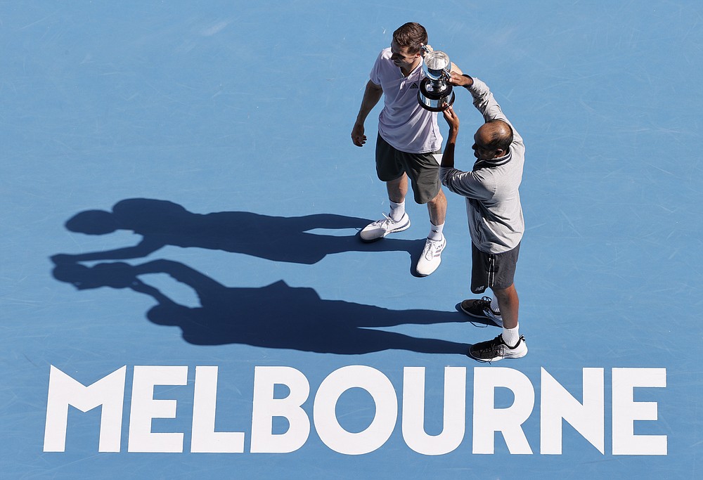 FILE - In this Feb. 2, 2020, file photo, Rajeev Ram, right, of the U.S. and partner Britain's Joe Salisbury hold their trophy after defeating Australia's Max Purcell and Luke Saville in the men's doubles final at the Australian Open tennis championship in Melbourne, Australia. Australian Open chief executive Craig Tiley says he wants international tennis players arriving for January's first Grand Slam of 2021 to be exempt from a current 14-day hotel quarantines. (AP Photo/Andy Wong, File)
