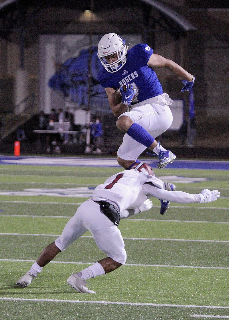 Rogers Mountaineers Senior Aron Rendon (4) leaps over Springdale Bulldogs Junior Davon Sparks (1) Friday, October 16, 2020, at Whitey Smith Stadium, Rogers, Arkansas (Special to NWA Democrat-Gazette/Brent Soule)