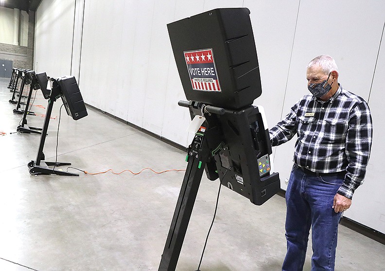 Garland County Election Commission Chairman Gene Haley sets up a voting machine at the Hot Springs Convention Center on Friday in preparation for the start of early voting on Monday. The center is one of seven early voting locations for the 2020 general election and nonpartisan run-off election. -  Photo by Richard Rasmussen of The Sentinel-Record