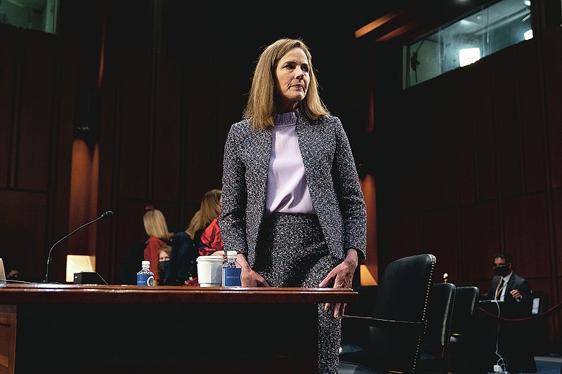 FILE - In this Wednesday, Oct. 14, 2020 file photo, Supreme Court nominee Amy Coney Barrett departs during a break in a confirmation hearing before the Senate Judiciary Committee on Capitol Hill in Washington. On Friday, Oct. 16, 2020, The Associated Press reported on stories circulating online incorrectly asserting that when reporters asked President Donald Trump why he nominated Barrett to replace the late Supreme Court Justice Ruth Bader Ginsburg, he said Barrett is “much better looking” than other women who have appeared on the court and “if people are more attractive, they get a fantastic amount of respect.” There is no evidence Trump made these comments. (Stefani Reynolds/Pool via AP)