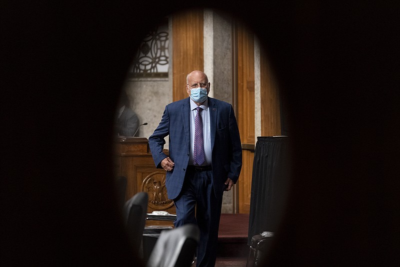 FILE - In this Wednesday, Sept. 16, 2020 file photo, Centers for Disease Control and Prevention Director Dr. Robert Redfield is seen through a door window as he appears at a Senate Appropriations subcommittee hearing on a "Review of Coronavirus Response Efforts" on Capitol Hill in Washington. Nina Bishop Witkofsky and Trey Moeller, two appointees assigned to the CDC's Atlanta headquarters in June 2020, have been tasked with keeping an eye on Redfield, as well as scientists, according to a half dozen CDC and administration officials who spoke to The Associated Press on the condition of anonymity to discuss internal government affairs. (AP Photo/Andrew Harnik, Pool)