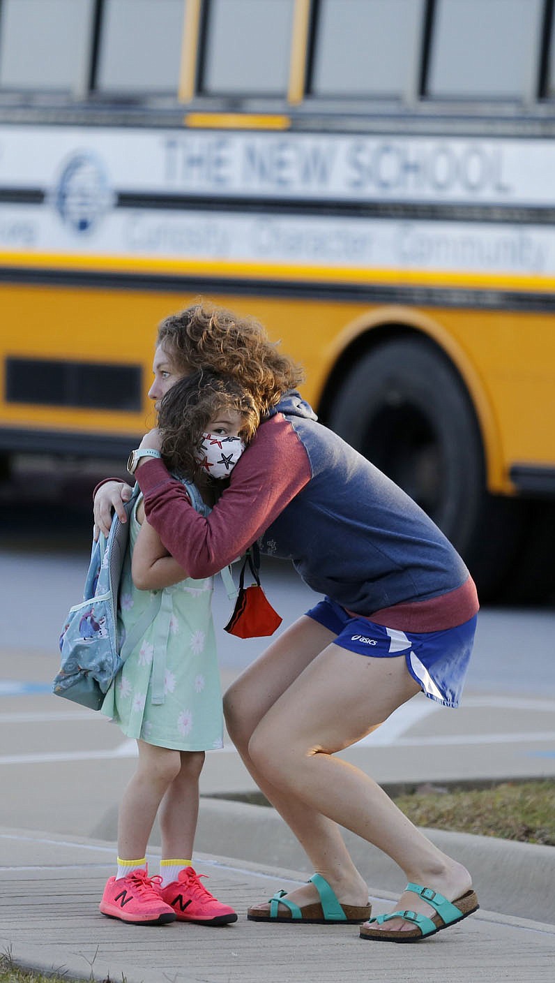 Bella Rose Robinson, a kindergarten student at The New School, receives a hug Thursday, October 1, 2020, before she enters school for a day of classes in Fayetteville. Check out nwadg.com/photos for a photo gallery.(NWA Democrat-Gazette/David Gottschalk)