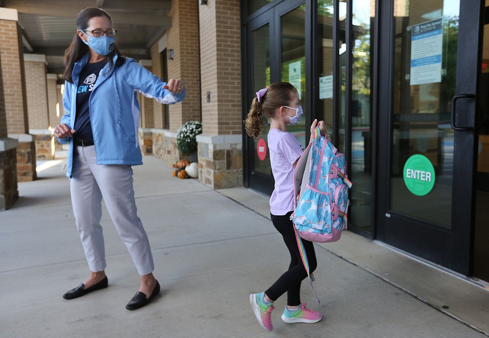 Nancy Lang, principal of The New School, greets Kindergarten student Harlow Hayes on Thursday, October 1, 2020, as she walks into the school for a day of classes in Fayetteville.  Visit nwadg.com/photos for a photo gallery.  (NWA Democrat-Gazette / David Gottschalk)
