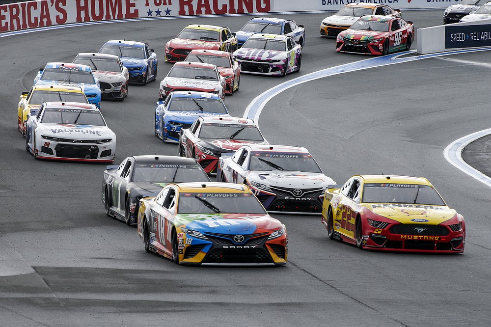 Kyle Busch (18) and Joey Logano (22) lead the pack out of Turn 2 in a NASCAR Cup Series auto race at Charlotte Motor Speedway in Concord, N.C., Sunday, Oct. 11, 2020. (AP Photo/Nell Redmond)
