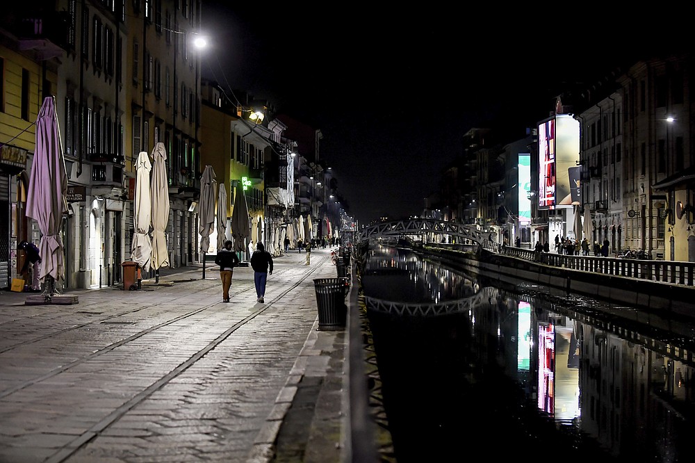 FILE - In this Sunday, March 8, 2020 file photo, the Navigli district of Milan, one of Milan's night life areas, is almost deserted after most bars were closed due to the coronavirus pandemic. Europe’s economy was just catching its breath from what had been the sharpest recession in modern history. A resurgence in coronavirus cases this month, Oct. 2020, risks undoing that and will likely turn what was meant to be a period of healing for the economy into a lean winter of job losses and bankruptcies. (Claudio Furlan/LaPresse via AP, File)