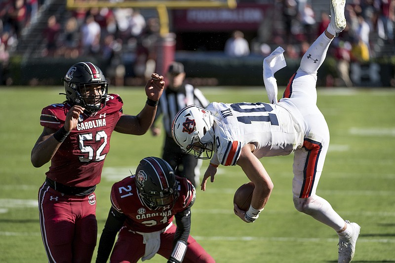 Auburn quarterback Bo Nix (10) is knocked out of bounds by South Carolina defensive back Shilo Sanders (21) and Kingsley Enagbare (52) during the second half of Saturday's game in Columbia, S.C. South Carolina defeated Auburn 30-22. - Photo by Sean Rayford of The Associated Press story.lead_photo.caption