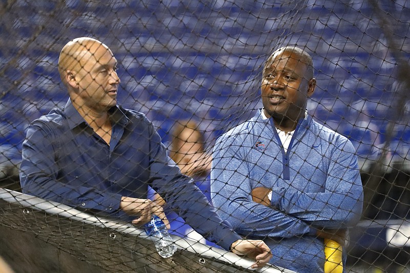 FILE - In this Wednesday, Aug. 28, 2019, file photo, Miami Marlins CEO Derek Jeter, left, and Michael Hill, President of Baseball Operations, watch batting practice before the start of a baseball game against the Cincinnati Reds, in Miami. Marlins executive Michael Hill's 19-season tenure with the franchise has ended. Hill was president of baseball operations for the past six years and provided continuity after a 2017 change in ownership, but he will not be back next year, CEO Derek Jeter said Sunday, Oct. 18, 2020.(AP Photo/Wilfredo Lee, File)