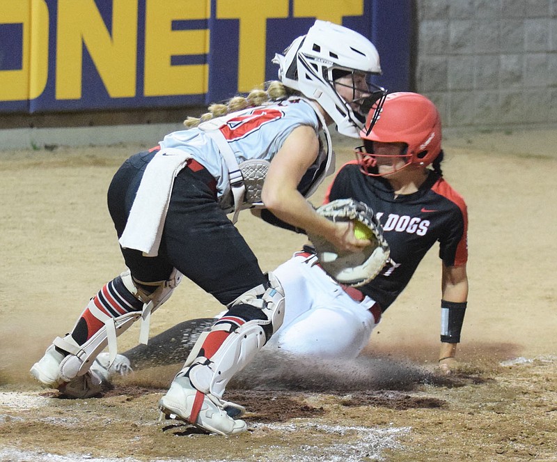 RICK PECK/SPECIAL TO MCDONALD COUNTY PRESS McDonald County catcher Reagan Myrick forces out Carl Junction's Bryn Neira at the plate during the Lady Mustangs' 2-1 win in the opening round of the Missouri Class 4 District 6 Softball Championships on Oct. 13 in Monett.