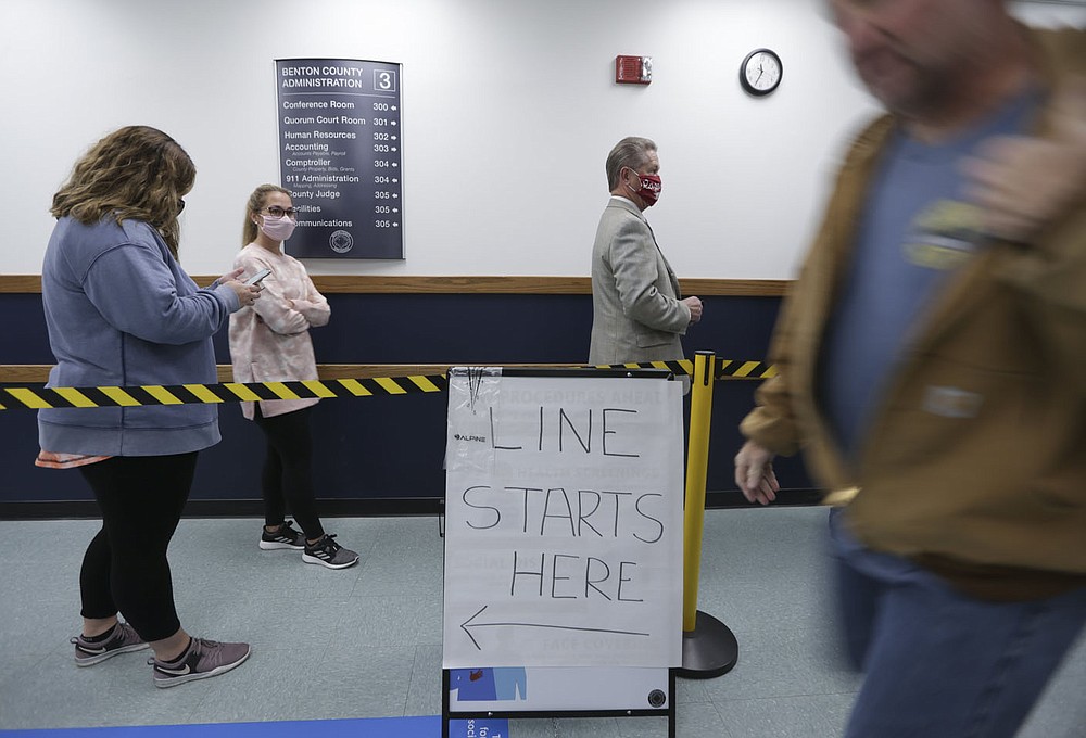 Voters wait in a line Monday at the Benton County Administration building in Bentonville. Early voting started Monday. The expanded and renovated Quorum Courtroom is being used as a early voting site. Go to nwaonline.com/201020Daily/ for today's photo gallery.
(NWA Democrat-Gazette/Charlie Kaijo)
