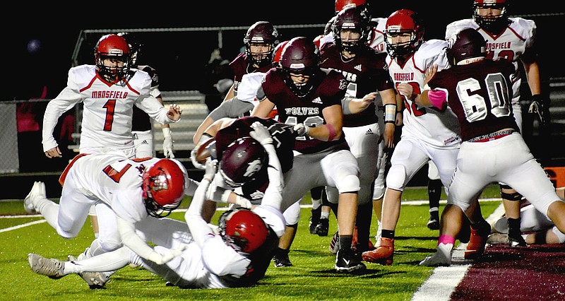 MARK HUMPHREY ENTERPRISE-LEADER/Lincoln senior tight end Audie Ramsey (No. 42) tries to pull tailback Matthew Sheridan across the goal line before his knees touch the turf during the Wolves' 52-6 win over Mansfield in Friday’s 3A-1 Conference victory.