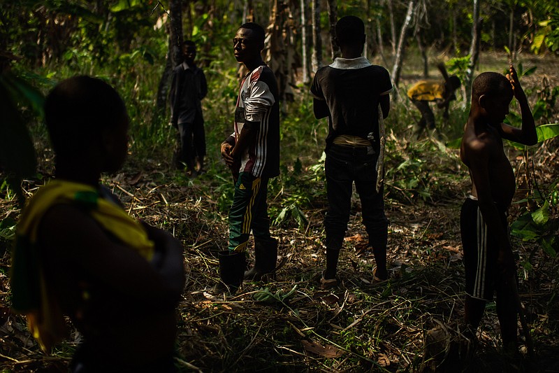 Children from Burkina Faso are seen on a cocoa farm during their break from cutting down trees and clearing bushes in 2019 in the West African nation of Ivory Coast. MUST CREDIT: Washington Post photo by Salwan Georges