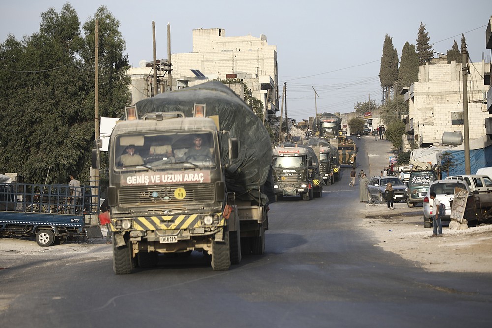 Turkish military convoy drives through the village of Urum al-Jawz, in Idlib province, Syria, Tuesday, Oct. 20, 2020. Turkish troops in northwestern Syria have been evacuating one of their largest military bases in the area, which was surrounded by Syrian government troops for months, activists said Tuesday. There was no immediate comment from Turkish officials. (AP Photo/Ghaith Alsayed)