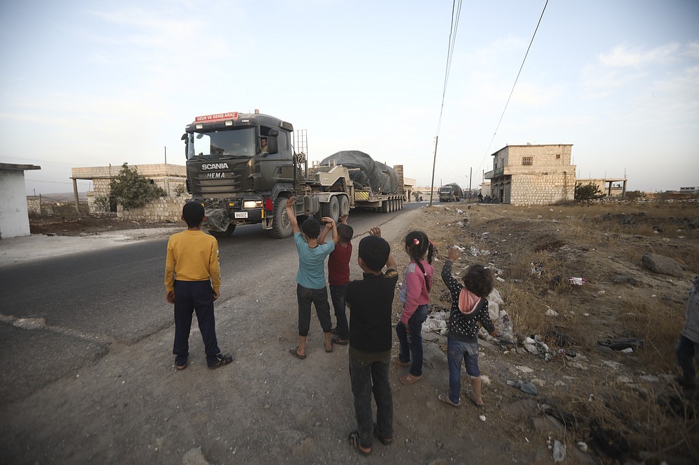 Turkish military convoy drives through the village of Urum al-Jawz, in Idlib province, Syria, Tuesday, Oct. 20, 2020. Turkish troops in northwestern Syria have been evacuating one of their largest military bases in the area, which was surrounded by Syrian government troops for months, activists said Tuesday. There was no immediate comment from Turkish officials. (AP Photo/Ghaith Alsayed)