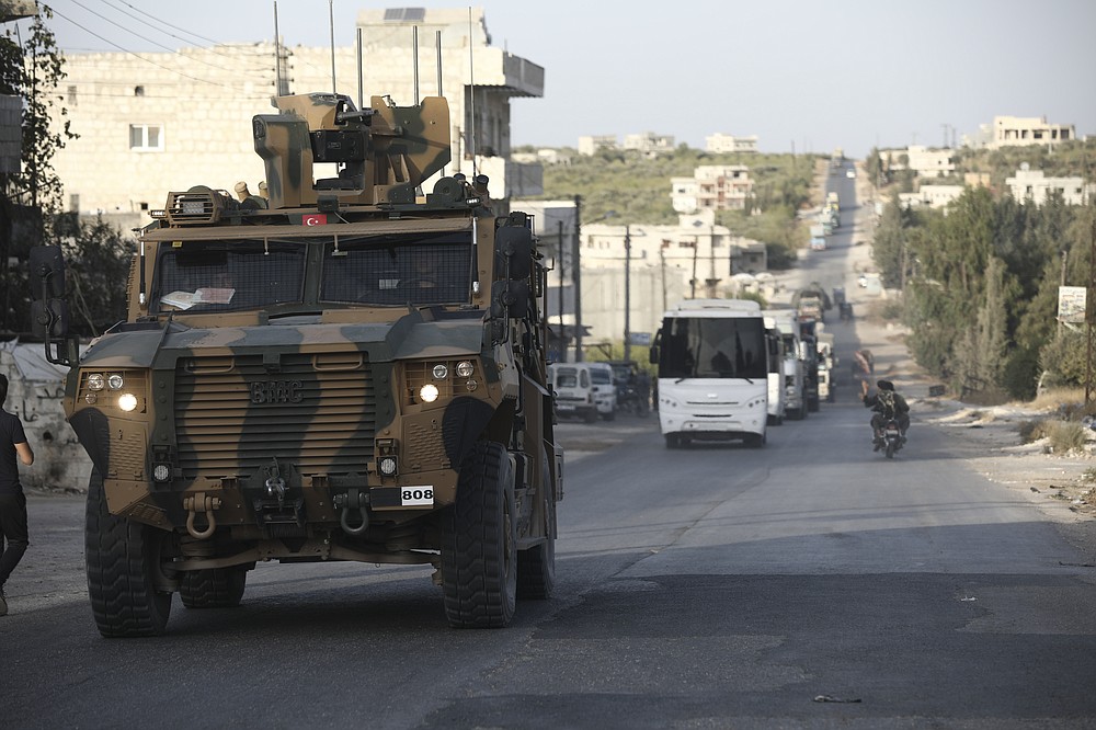 Turkish military convoy drives through the village of Urum al-Jawz, in Idlib province, Syria, Tuesday, Oct. 20, 2020. Turkish troops in northwestern Syria have been evacuating one of their largest military bases in the area, which was surrounded by Syrian government troops for months, activists said Tuesday. There was no immediate comment from Turkish officials. (AP Photo/Ghaith Alsayed)
