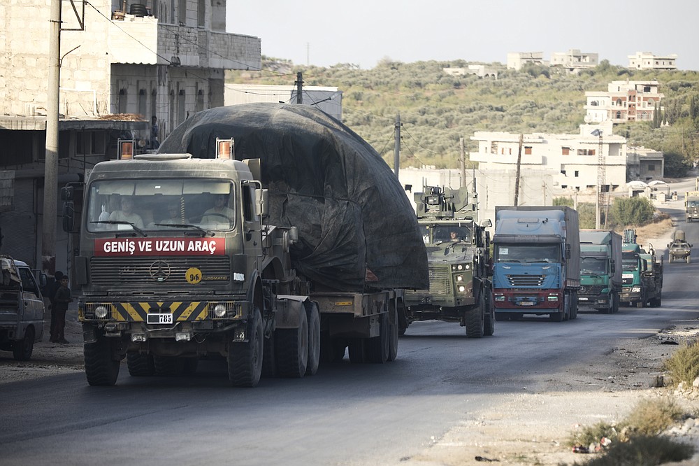 Turkish military convoy drives through the village of Urum al-Jawz, in Idlib province, Syria, Tuesday, Oct. 20, 2020. Turkish troops in northwestern Syria have been evacuating one of their largest military bases in the area, which was surrounded by Syrian government troops for months, activists said Tuesday. There was no immediate comment from Turkish officials. (AP Photo/Ghaith Alsayed)