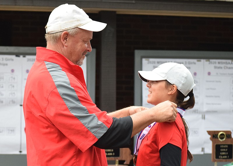 RICK PECK/SPECIAL TO MCDONALD COUNTY PRESS
Lily Allman receives her third place medal at the Missouri State Class 3 Girls Golf Championships from McDonald County golf coach Darryl Harbaugh.