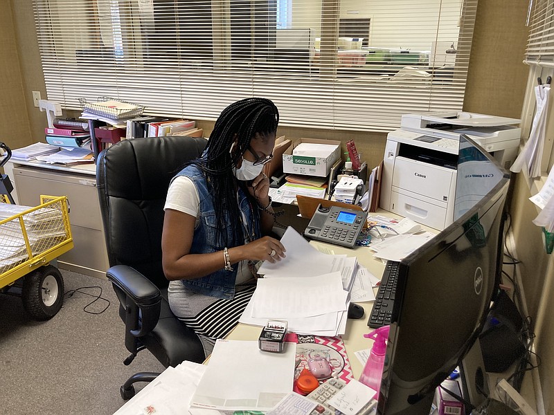 Jefferson County Clerk Shawndra Taggart helps a caller on Wednesday as she takes a moment away from a line of voters that extended out the door of the courthouse and around the side. Record numbers of voters have been early voting this week across the state and nation, with local numbers up by almost 25 percent. (Pine Bluff Commercial/Byron Tate)