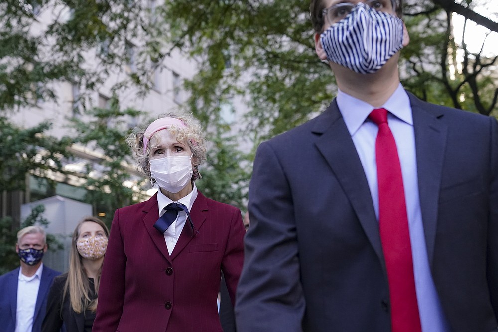 E. Jean Carroll, left, who says President Donald Trump raped her in the 1990s, leaves the Daniel Patrick Moynihan United States Courthouse following a hearing in her defamation lawsuit against Trump, Wednesday, Oct. 21, 2020, in New York. (AP Photo/John Minchillo)