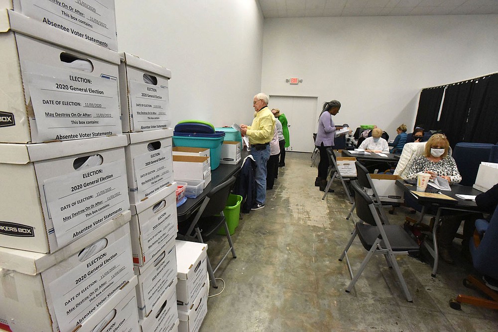 Boxes of processed absentee ballots are seen Wednesday Oct. 28 2020 near workers processing more absentee ballots at the Benton County Election Commission office in Rogers.
(NWA Democrat-Gazette/Flip Putthoff)